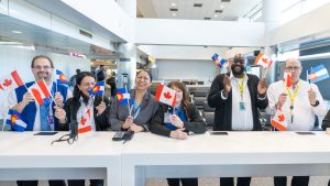 Line of United employees waving Colorado and Canada flags to celebrate the inaugural flight to Regina, Canada.