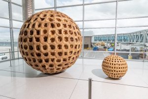 Colorado-based artist Terry Maker’s large-scale Cowgirl Hat Ball—a 10-foot sphere constructed from more than 500 straw hats—and Cowgirl Hat – 2, a companion piece made from 175 miniature hats is on display on Concourse B, near gate B62, through January 2027.